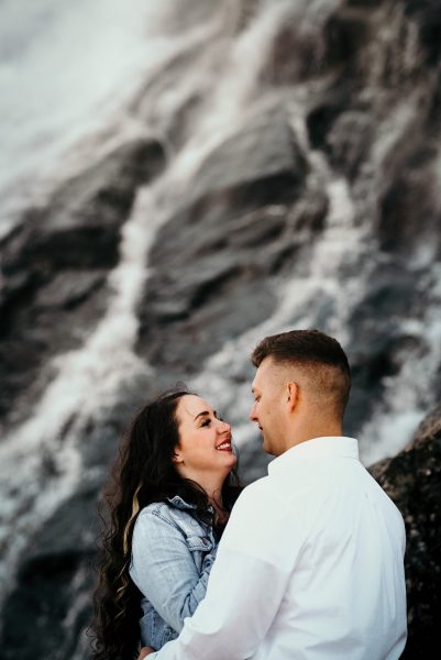 engagement photos in front of a waterfall in alaska