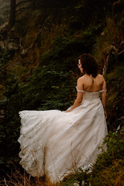 Bride standing along the coast of Maine in wedding dress