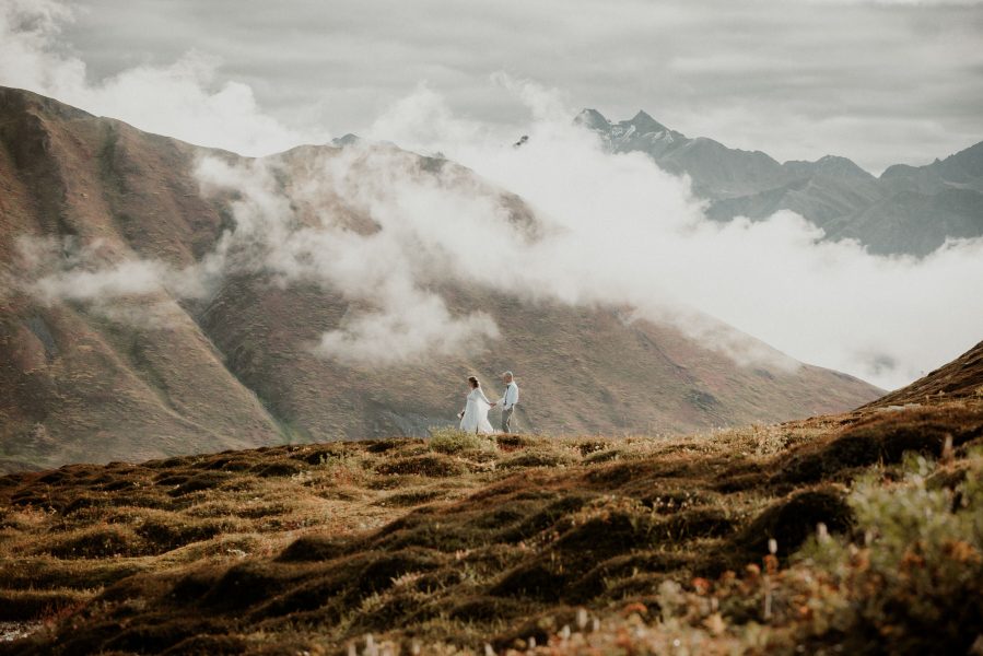 bride and groom walking mountain ridge in hatcher pass