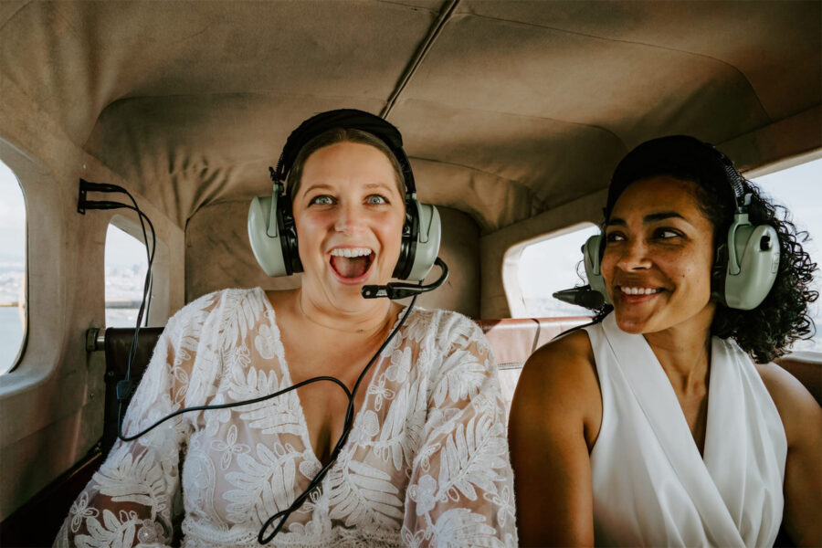 couple smiling ecstatic during elopement seaplane adventure over san francisco
