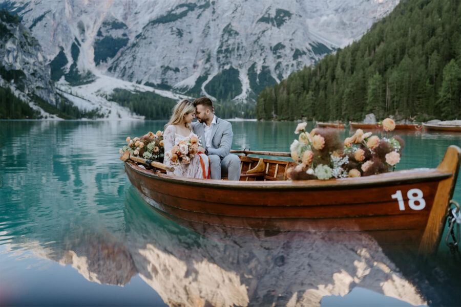 bride and groom in a canoe on the water of Lago Di braies