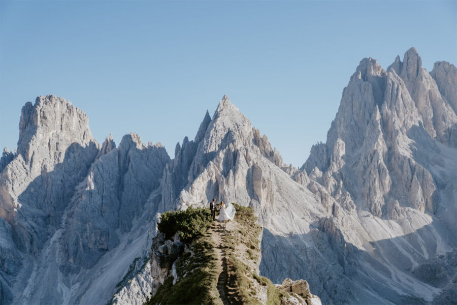 wide shot of bride and groom in the dolomite mountains