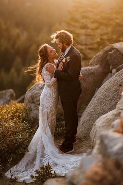 Sunset elopement portrait in Lake Tahoe. Couple on a cliff at sunset in wedding attire.
