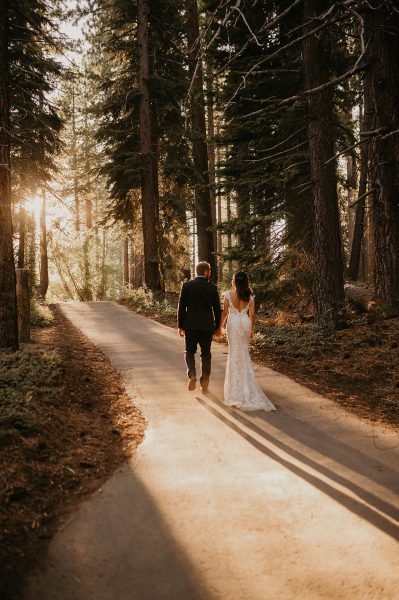 Sunset elopement portrait in Lake Tahoe. Couple walks at sunset in wedding attire.
