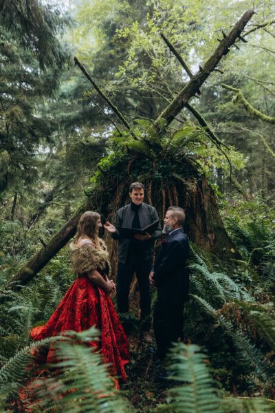 Couple exchanging vows during a forest ceremony at Ecola State Park on the Oregon Coast surrounded by ferns and mossy trees