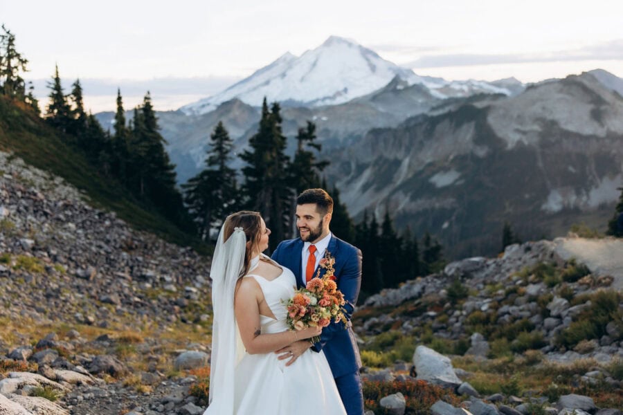 Bride and groom holding a bouquet at Artist Point with Mount Baker in the background, Washington