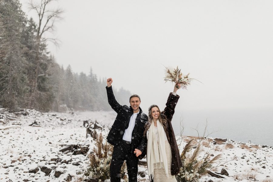 Bride and groom cheering after a ceremony in the snow in Cle Elum