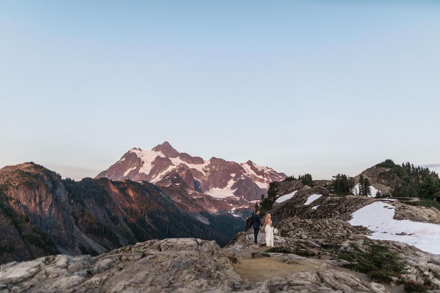 Couple walking with the sun setting on the North Cascade Mountain Range