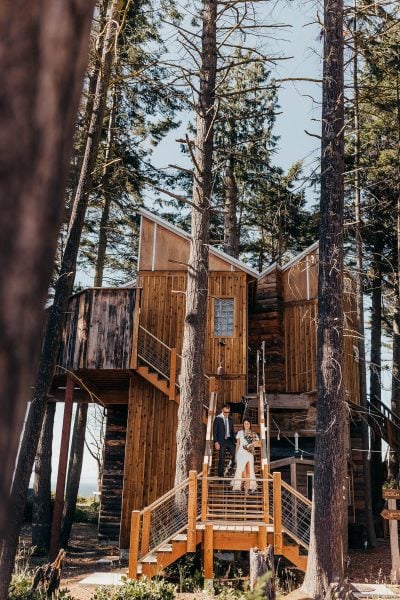 Bride and groom departing down treehouse stairs