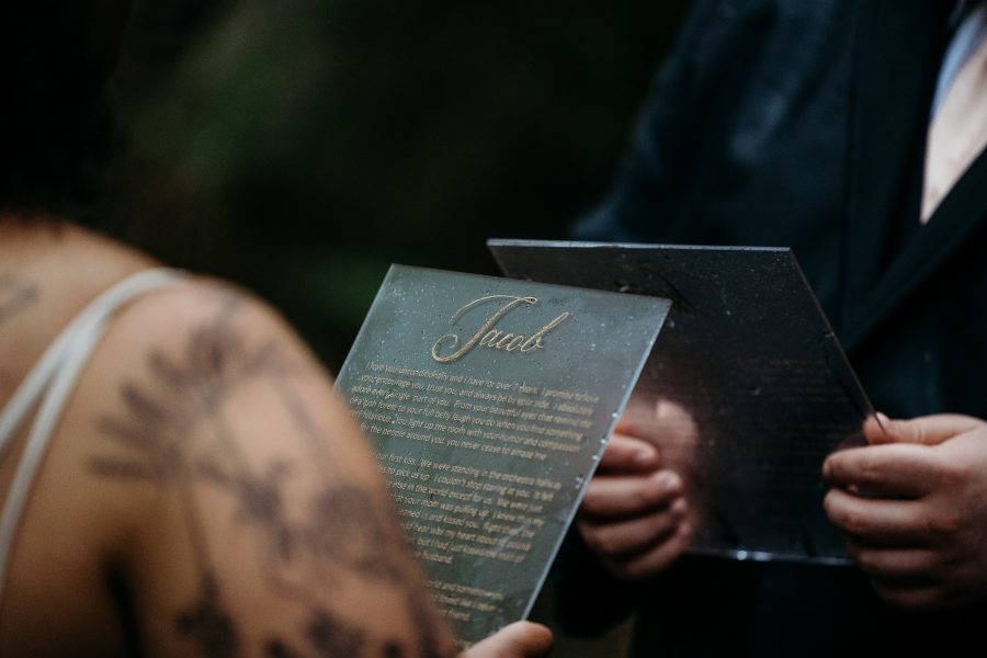 Couple holding vows engraved in glass