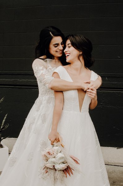 Two brides embrace lovingly on their elopement day