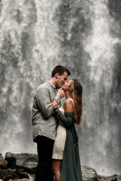 Newlywed couple kisses beneath Ozone Falls Waterfall in the Blue Ridge Mountains