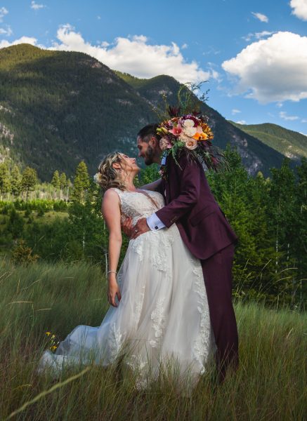 bride and groom in front of a mountain in radium hot springs