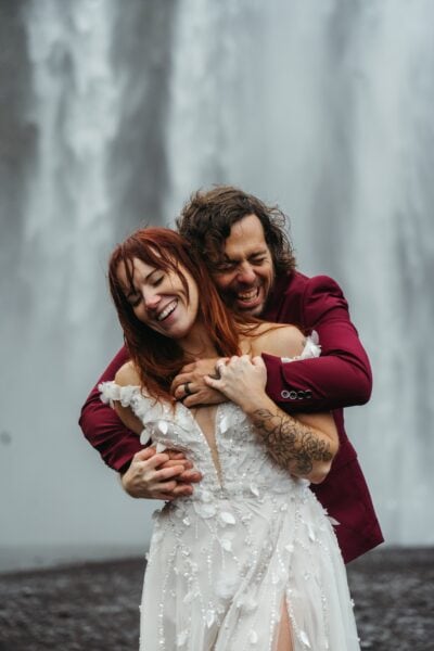 Couple eloping at SKÓGAFOSS in Iceland with waterfall in background