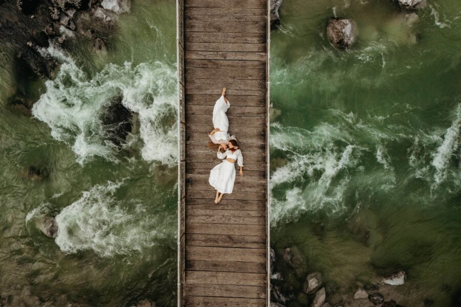 Couple laying on a bridger overlooking Soča river during elopement