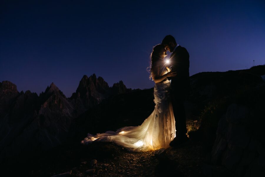 Couple eloping at Cadini di Misurina and Tre Cime with bride's dress well lit