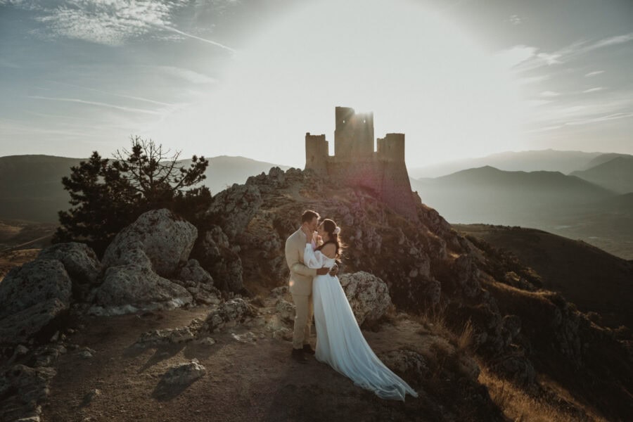 bride and groom in front of Rocca Calascio, during their elopement in Abruzzo, Italy
