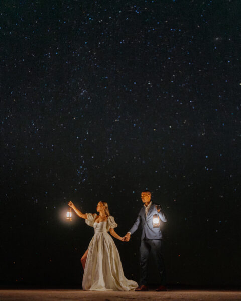Bride and groom holding lanterns while eloping at Bonneville Salt Flats in Utah.