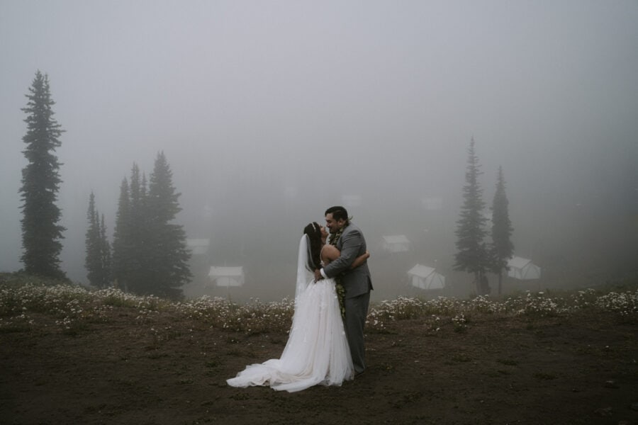 Just married! Jesus and Jocelyn embrace on a fog-covered mountain, overlooking Crystal Sky Camp tents.