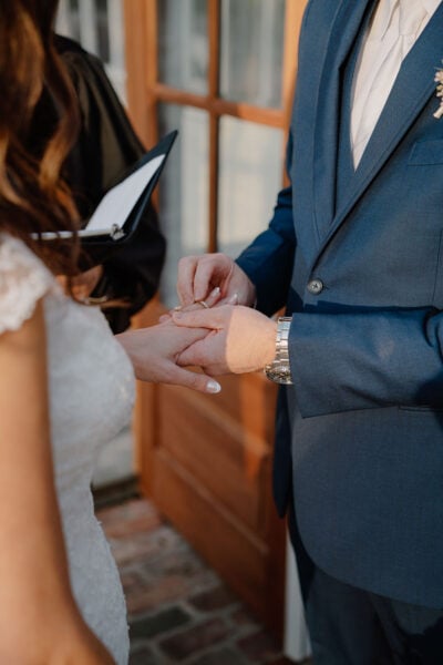 photo of groom putting on bride's wedding ring