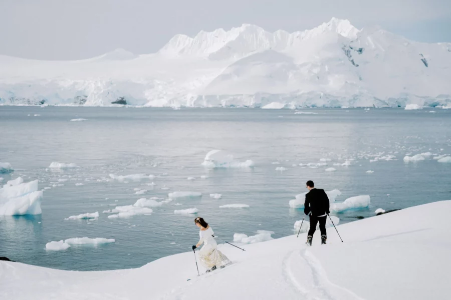 bride and groom skiing down a glacier above the sea in Antarctica