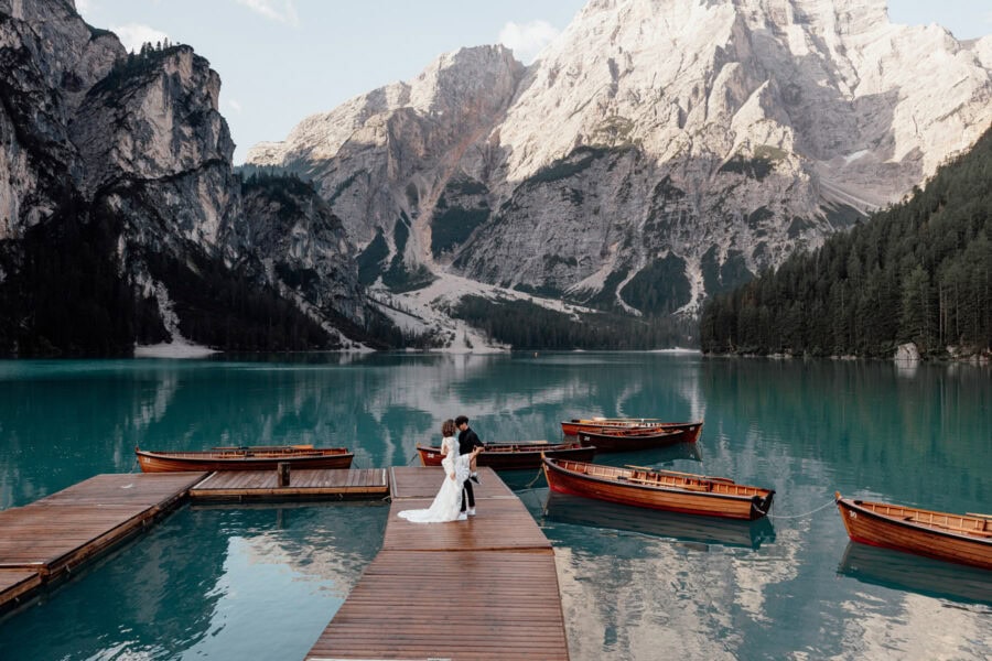Elopement Couple standing on the docks of boathouse La Palafitta on lago di Braies in the Dolomites