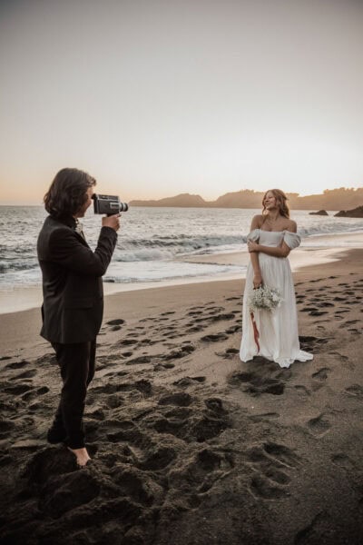 Romantic photo of the bride and groom embracing on a foggy black sand beach in San Francisco.