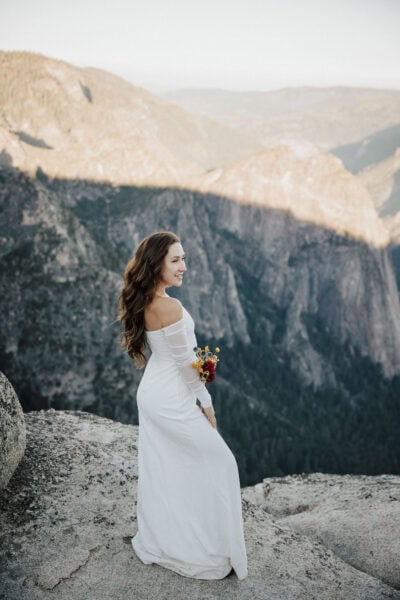 Epic Yosemite elopement with the couple standing on a rocky overlook at sunrise