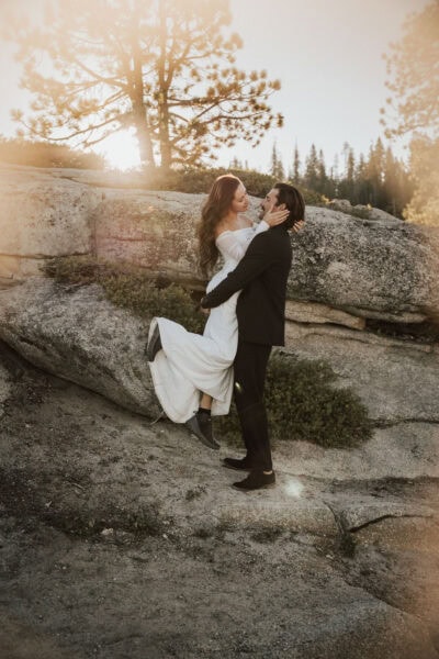 Adventurous bride hiking in her wedding dress along a scenic Yosemite trail