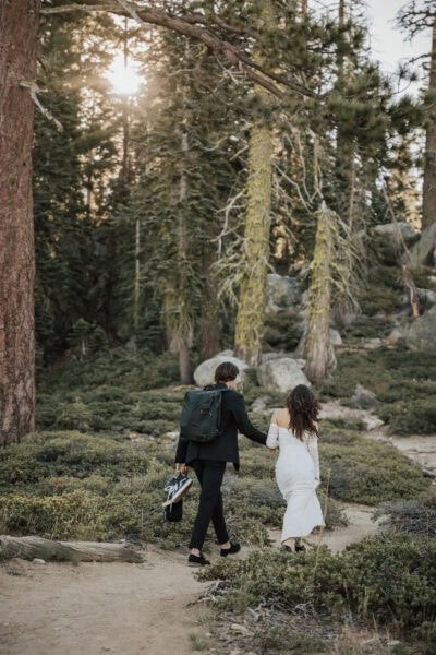 Adventurous bride hiking in her wedding dress along a scenic Yosemite trail