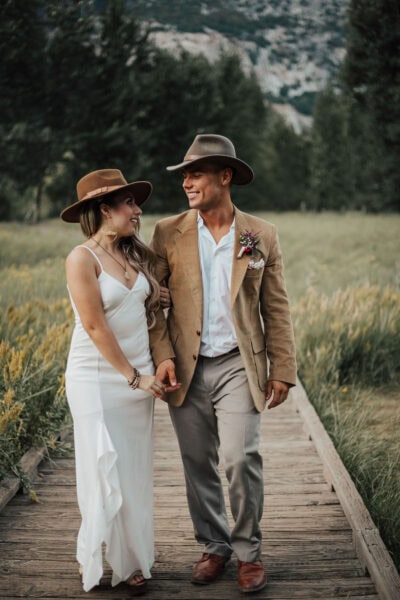Elopement couple walking hand-in-hand through a sunlit meadow in Yosemite National Park