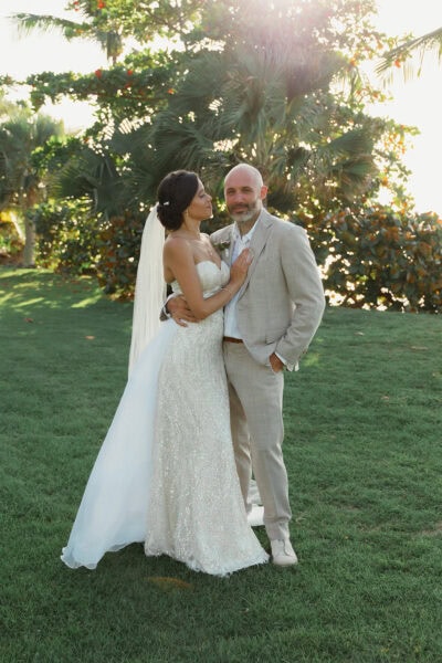 Man and Woman standing together after getting married, with her in a white dress looking lovingly at him