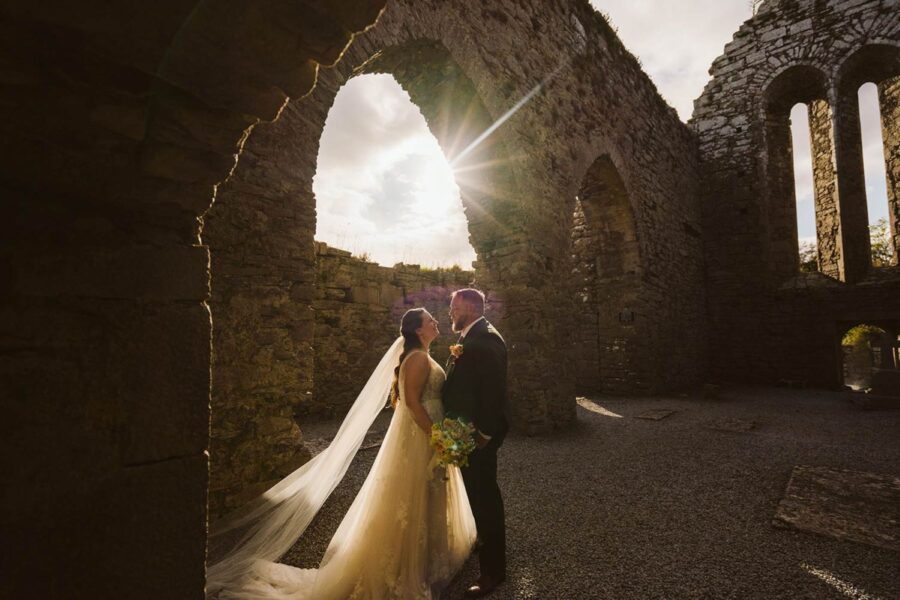 Couple eloping on cliffs at sunset in Ireland in an Abbey ruin