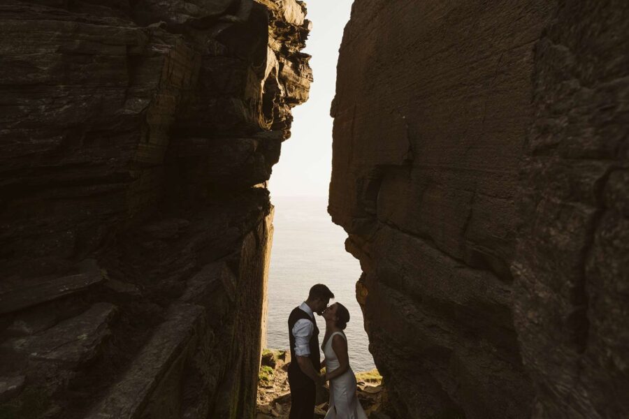 Couple eloping on the Cliffs in a stone gap in Ireland