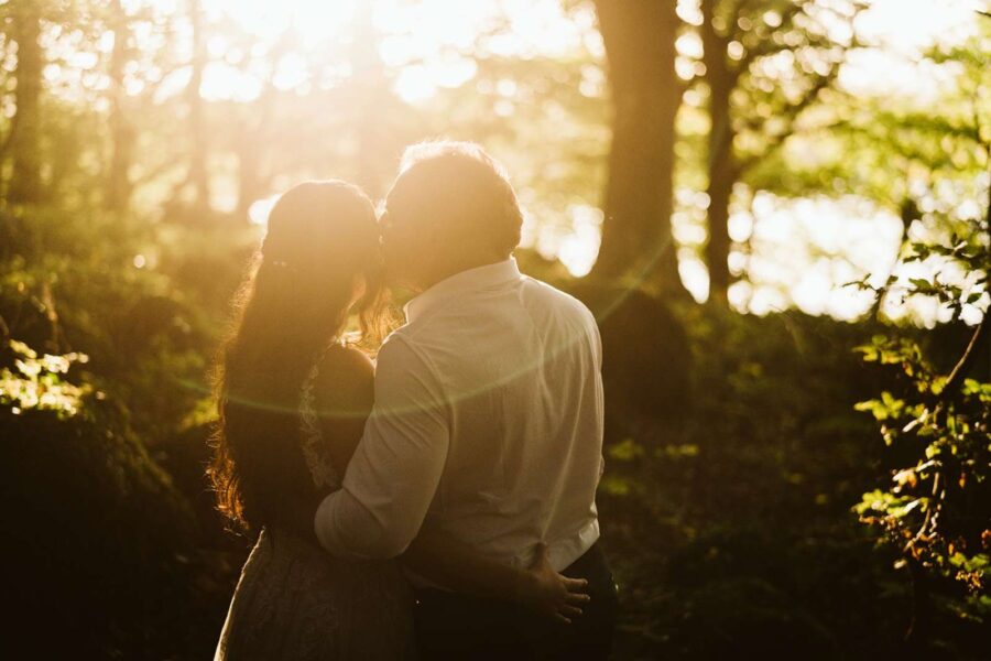 A couple kissing in the woods at sunset while eloping in Ireland